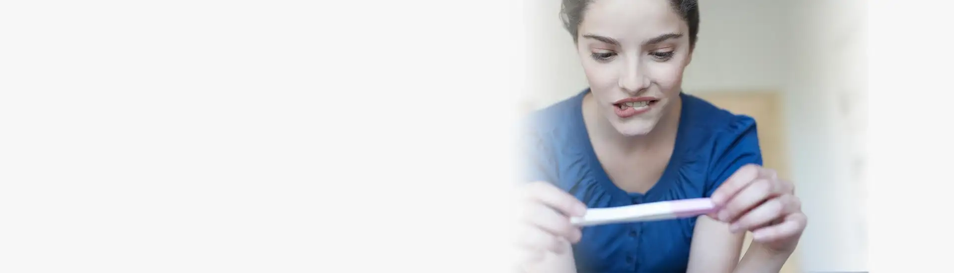 Anxious woman looking at pregnancy test - Pregnancy Help in Arizona