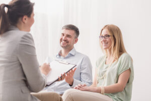 A social worker is talking to a couple.